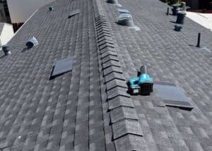 New asphalt shingle roof with roof vents and skylights on a residential home.