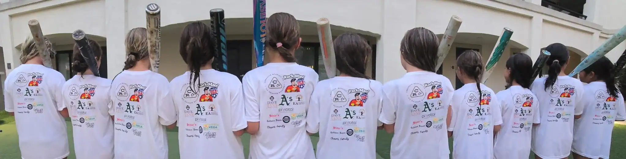 spnosorship team pic Group of roofers in white shirts with logos, standing with backs, holding roofing tools.